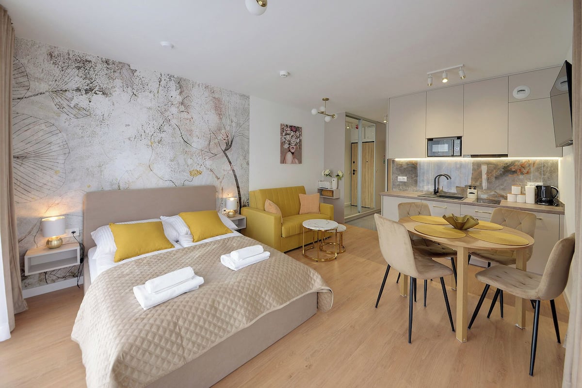 Une chambre d’hôtel moderne dotée d’un grand lit, d’un canapé, d’un coin repas et d’une cuisine.