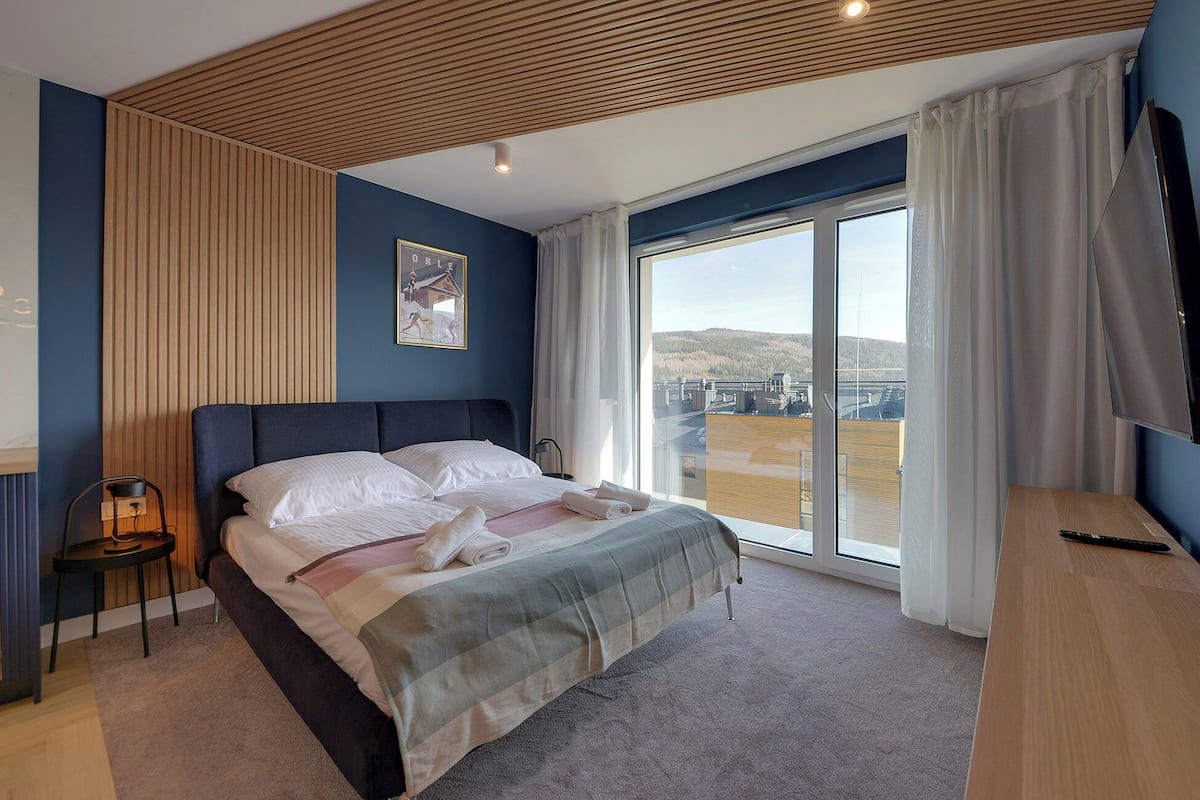 Une chambre d’hôtel moderne avec un grand lit, une vue sur un pont et un téléviseur à écran plat.