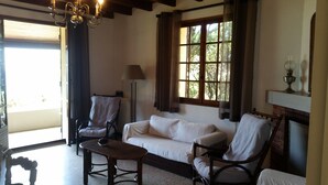 A cozy living room with a sofa, two armchairs, a wooden coffee table, and a fireplace. - House (Calcatoggio)