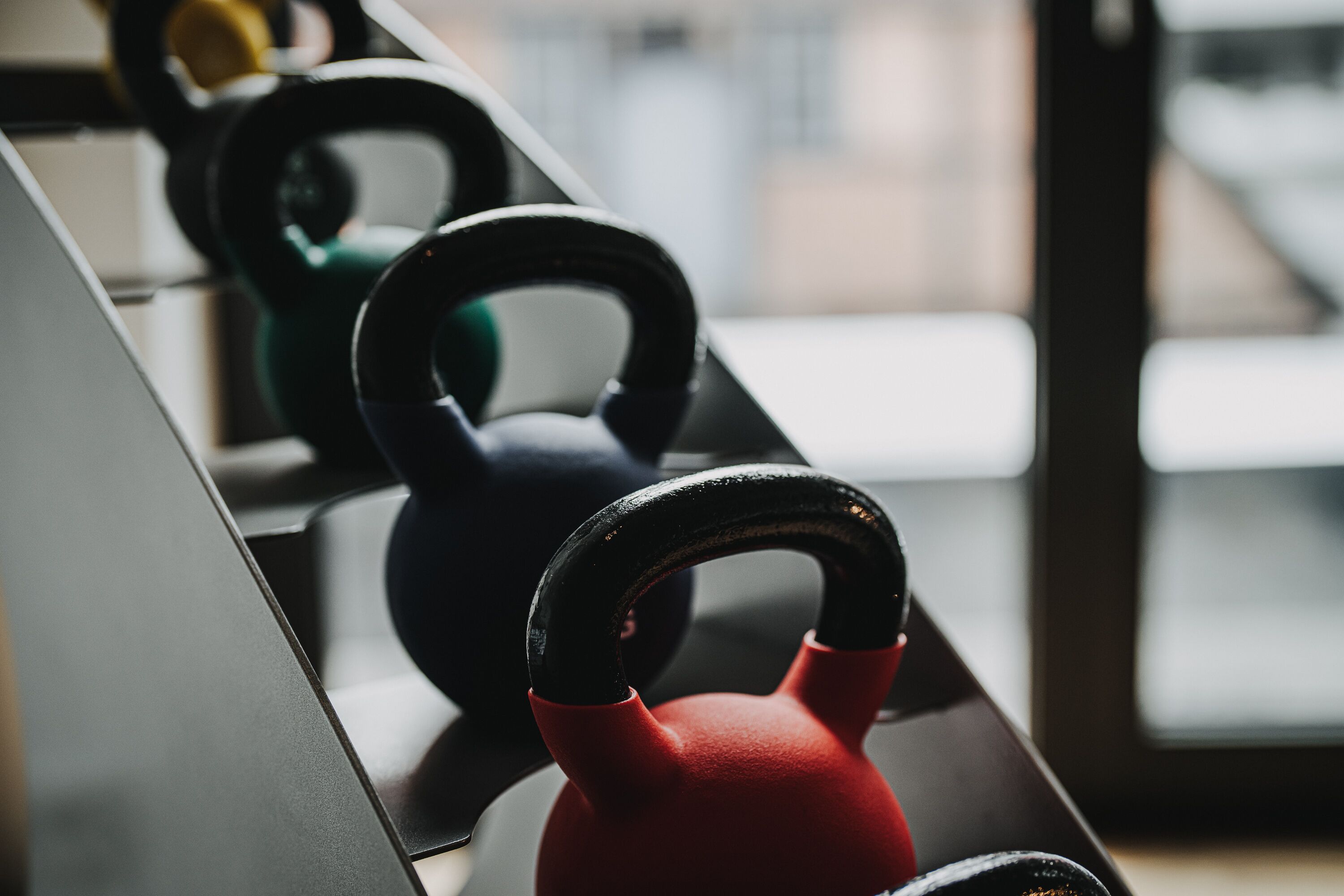 Una fila de kettlebells en un gimnasio.
