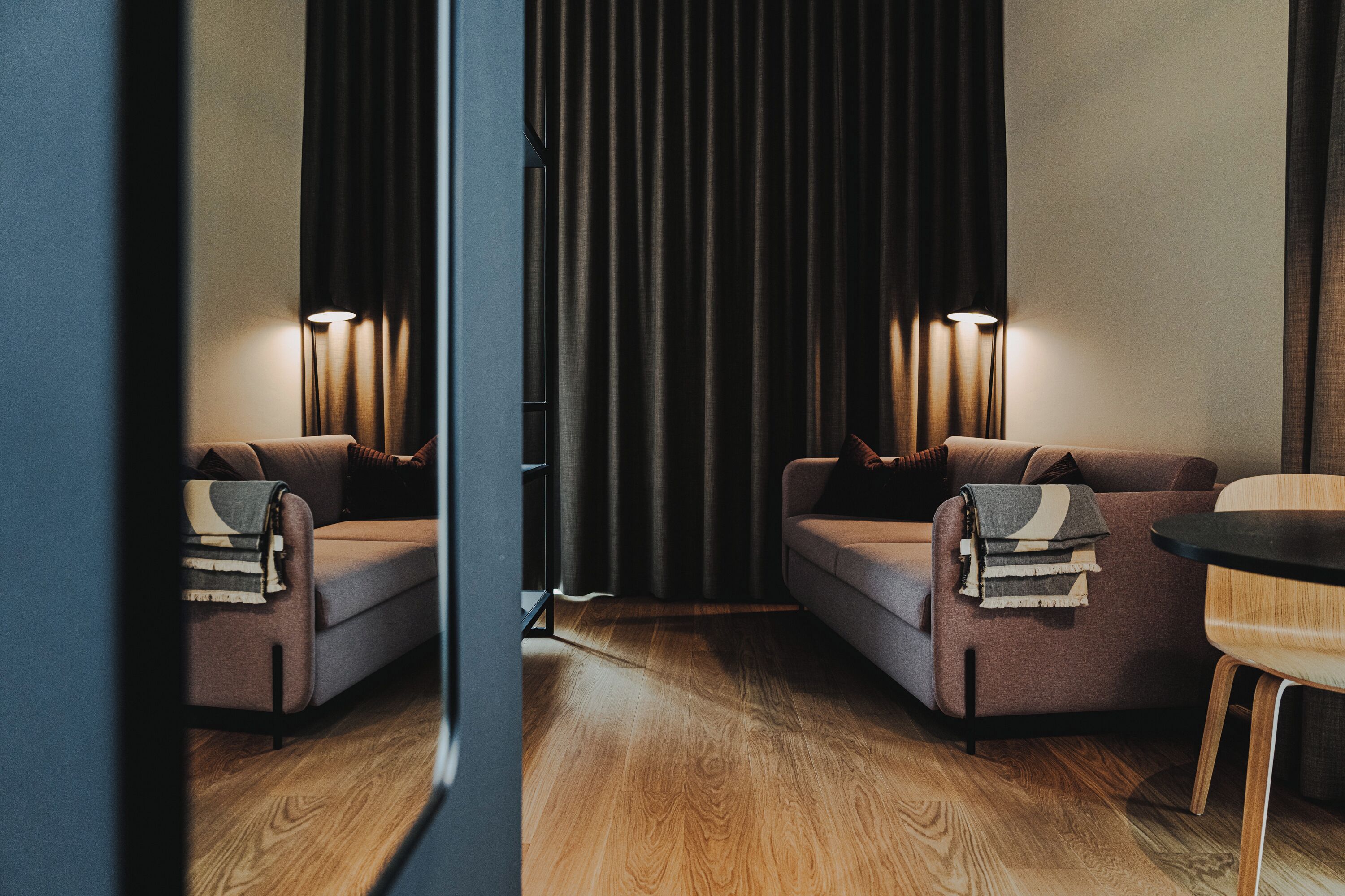 Una habitación moderna con dos sofás, una mesita y un fondo de cortina.