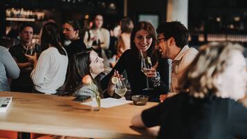 A group of people sitting around a bar area with a visible menu and a bottle on the table.