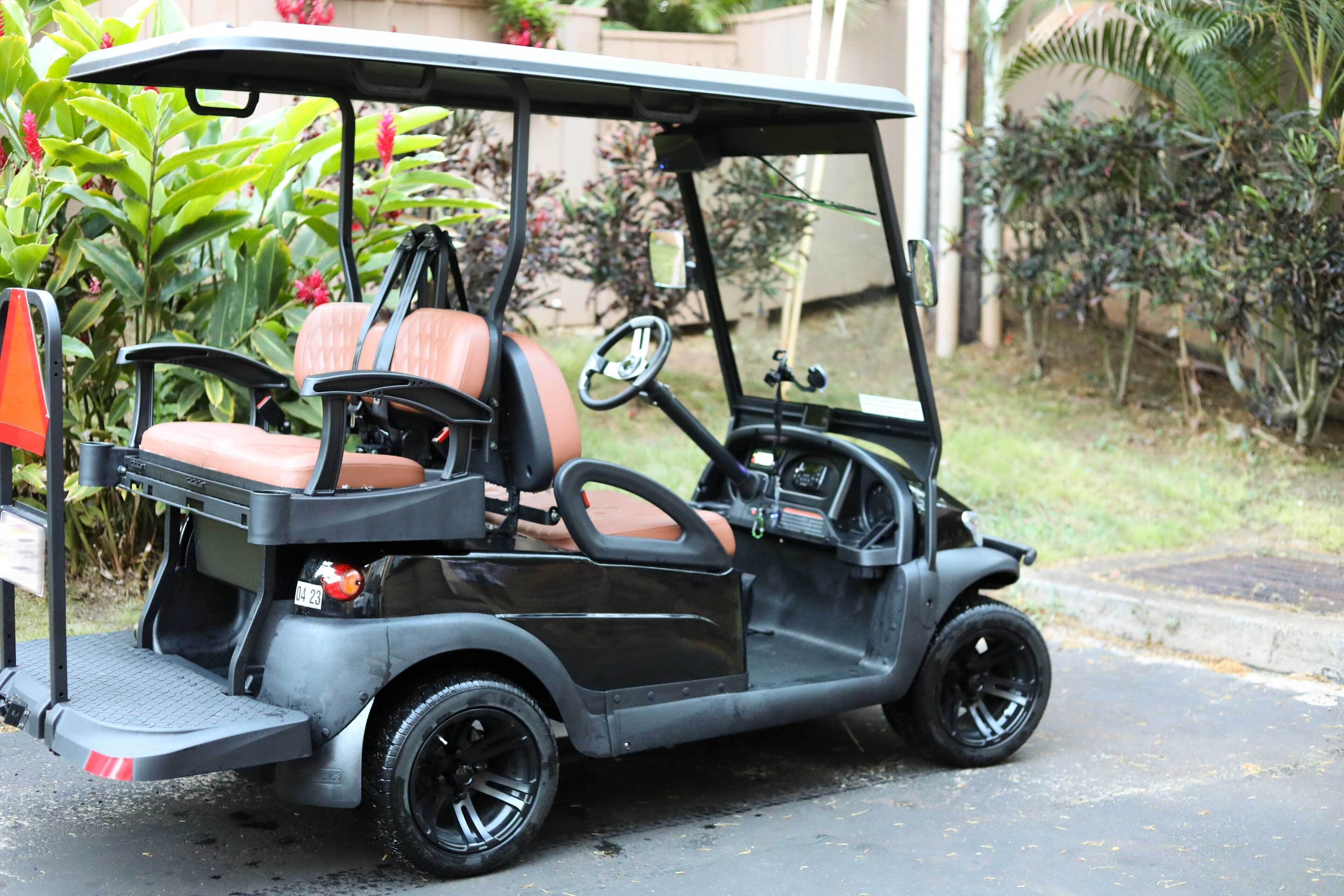 Une voiturette de golf est garée dans une rue résidentielle.