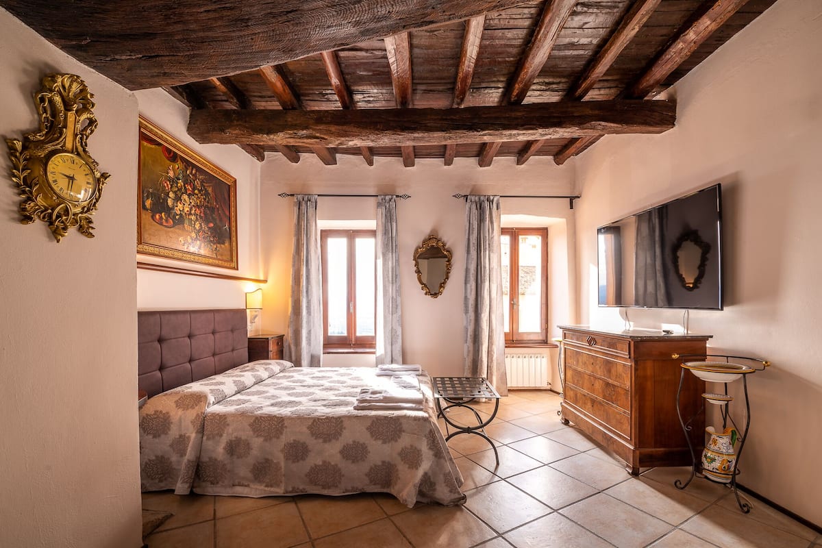 A bedroom with a bed, dresser, and a television.