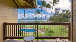 Un balcon avec vue sur une piscine et un paysage tropical.