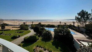 Un espace piscine offrant une vue sur la plage et l’océan.
