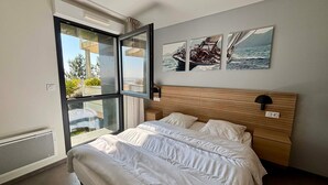 Une chambre à coucher avec un lit, une fenêtre et trois tableaux accrochés au mur.