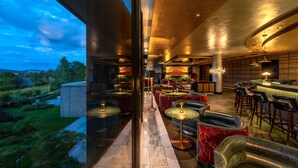 Un interior moderno con una zona de bar, asientos y vistas al exterior.