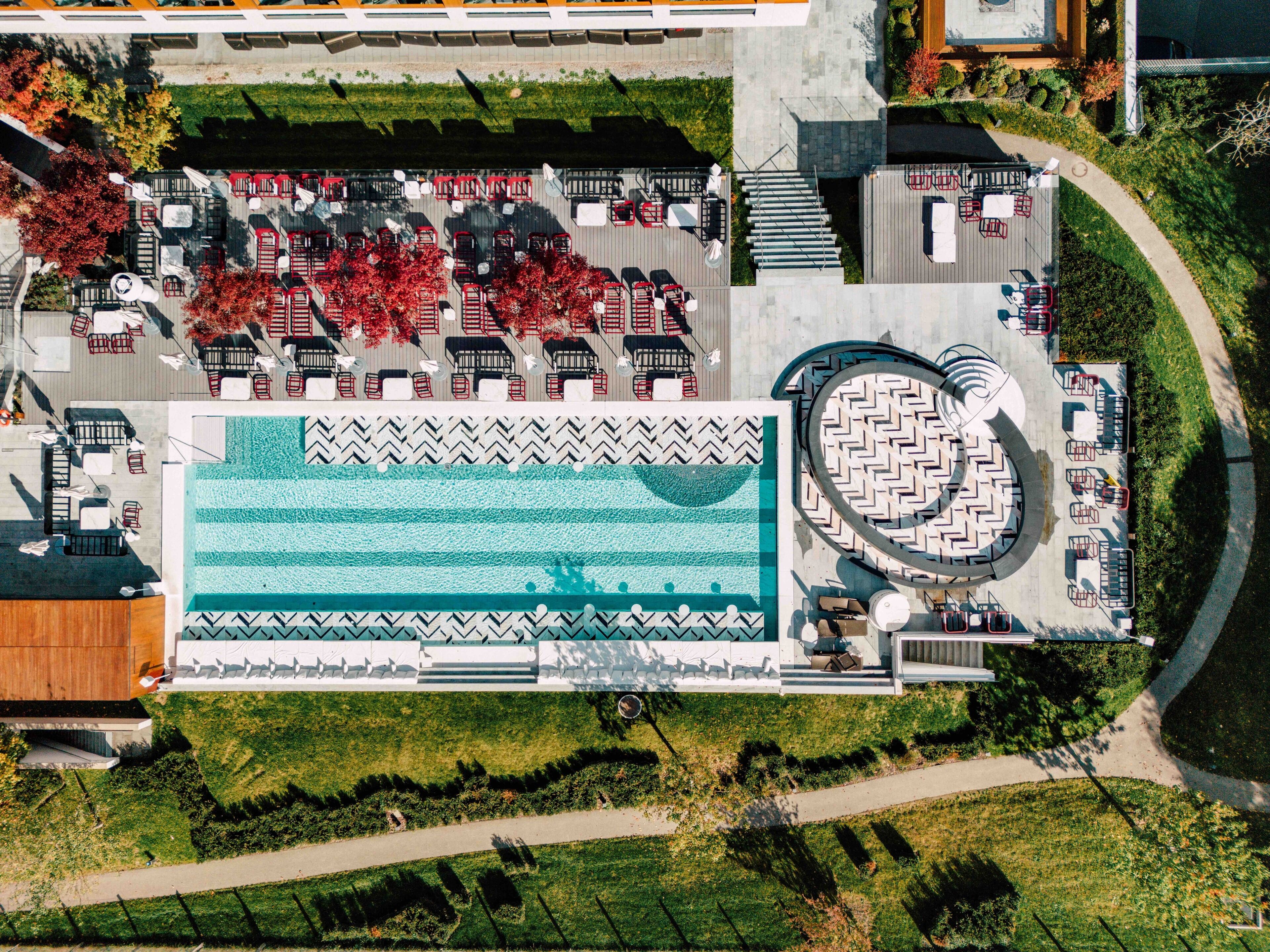 Vista aérea de un hotel con piscina, zonas de estar al aire libre y un jardín ajardinado.