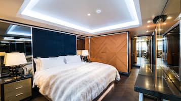 Habitación de hotel moderna con una cama grande, una mesita de noche con lámpara, un panel de madera decorativo y un espejo amplio.