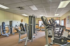 Un gimnasio con diferentes máquinas de ejercicio, una cinta de correr y un equipo de aire acondicionado instalado en la pared.