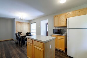 A kitchen with wooden cabinets, a granite countertop, and a built-in microwave.