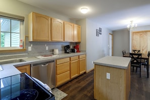 A kitchen with wooden cabinets, a dishwasher, and a coffee maker.