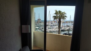 Un balcon avec vue sur un port de plaisance, un canapé et une lampe.