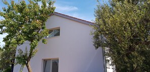 A two-story building with a flat roof and a small window on the second floor.