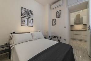 Une chambre à coucher comprenant un lit, une table de chevet et une œuvre d’art accrochée au mur.