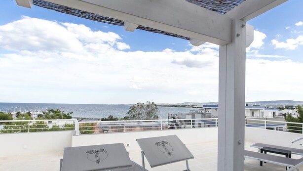A terrace with two tables and chairs, overlooking a coastal view with a clear sky. - Via del Faro Apartments - SUD - OVEST (Torre Canne)