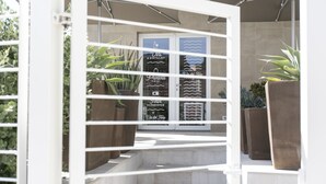 A set of outdoor stairs leading to a building entrance with a glass door. - Via del Faro Apartments - SUD - OVEST (Torre Canne)