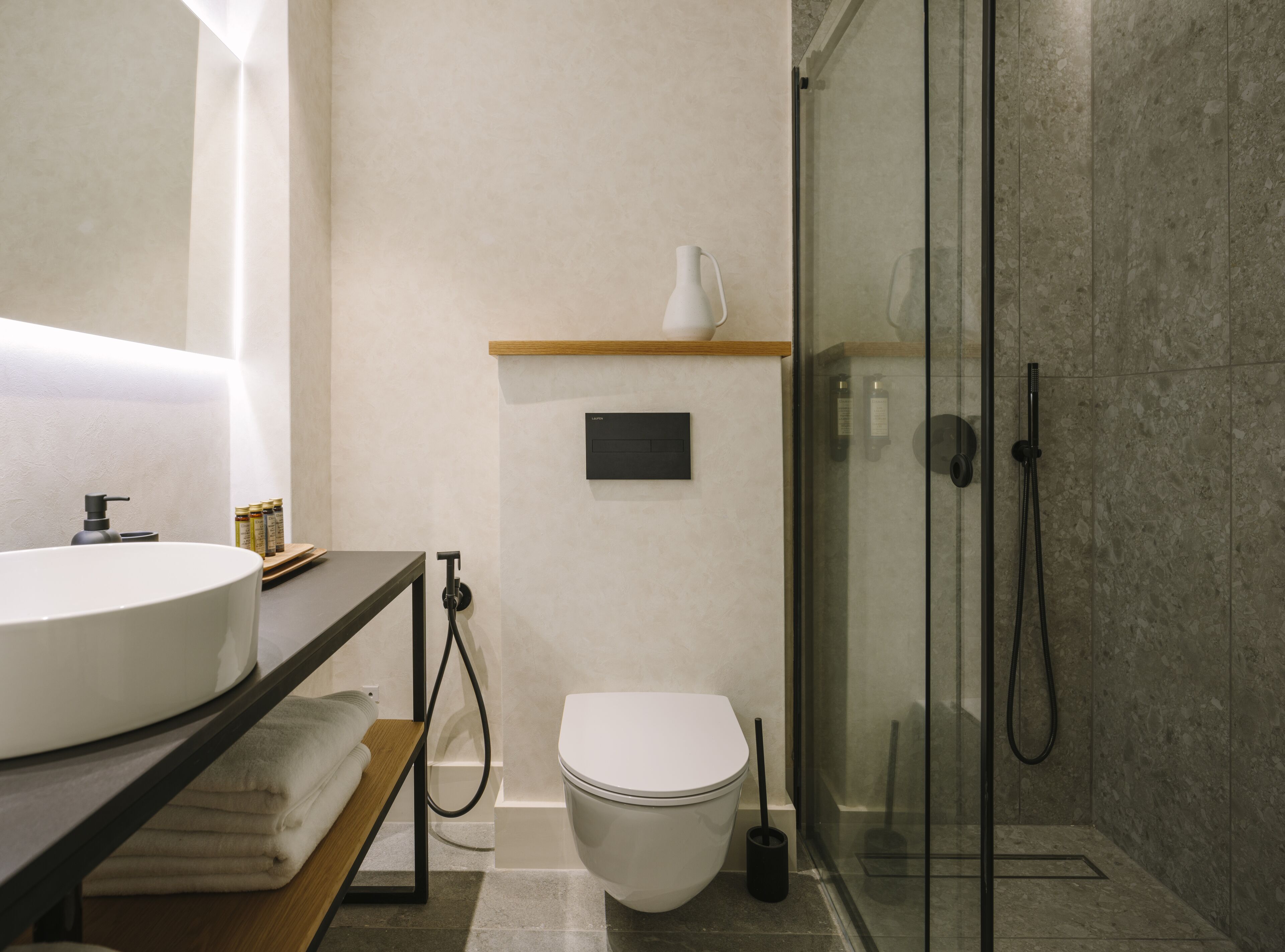Ein modernes Badezimmer mit einem großen Waschbecken, Toilette und einer Duschkabine aus Glas.
