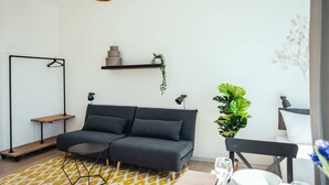 Una sala de estar moderna con un sofá gris, una mesa de centro redonda y un tapete amarillo estampado.