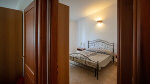 A bedroom with a bed, bedside table, and a wall-mounted light fixture. - Villa con Piscina - BUDONI (San Lorenzo)