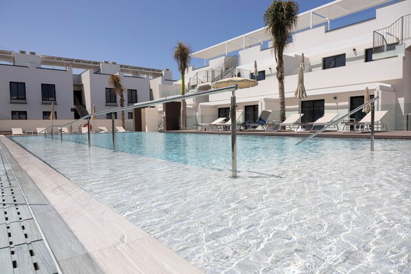 Een buitenzwembad en ligstoelen