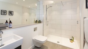 Un baño moderno con ducha, inodoro y lavamanos.