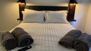 A neatly made bed with white linens, two rolled towels, and a remote control on the bed. - Luxury 2 Bed/2 Shower Room Apartment in Bath City (Bath)