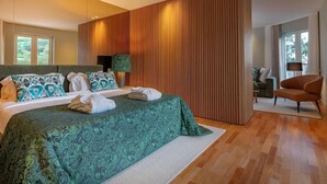 A modern bedroom with a large bed, a wooden accent wall, and a view of the outdoors.