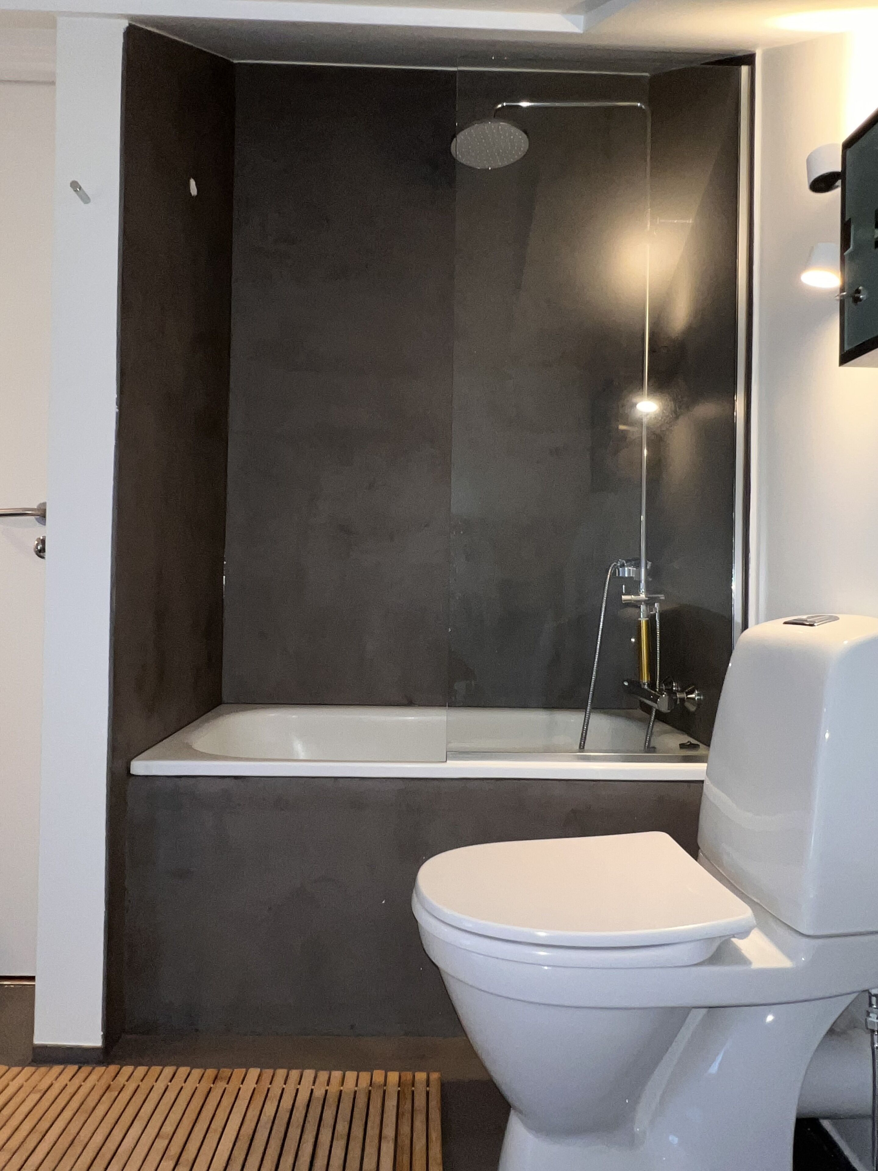Ein modernes Badezimmer mit Badewanne, Toilette und Duschbereich.