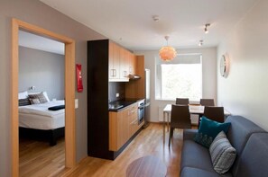 Un espacio habitable pequeño con kitchenette, comedor y dormitorio.