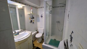 A bathroom with a sink, toilet, and glass-enclosed shower. - Apartment Biarritz - Quartier Saint Martin (Biarritz)