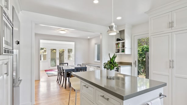 A modern kitchen with white cabinetry, a central island, and a dining area with a table and chairs. - Casita Palo Alto - 2 Bed 2 Bath / Private Back Yard / WiFi (Palo Alto)