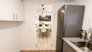 Une cuisine moderne équipée d’un réfrigérateur en acier inoxydable, d’un évier et d’un coin repas avec une table et des chaises.