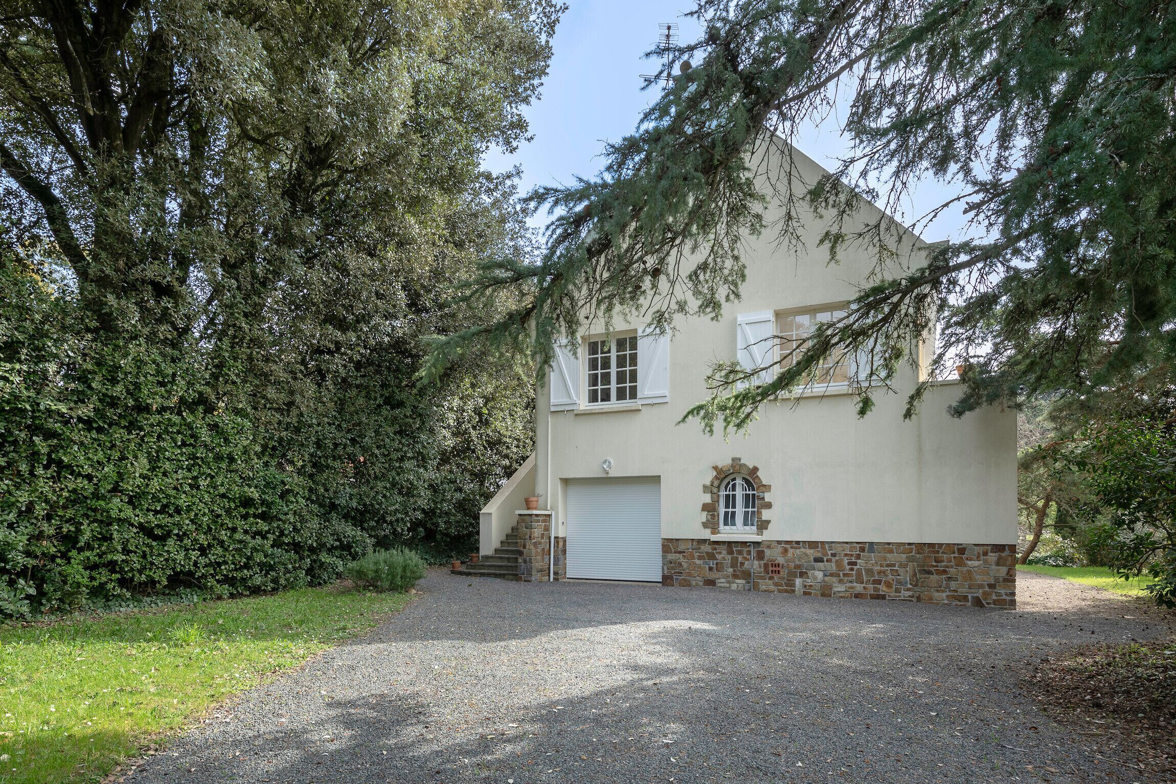 A two-story house with a stone foundation and a white exterior.