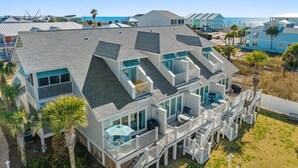 A multi-story beachfront house with multiple balconies, a covered patio, and a view of the ocean. - Beachside Townhome w/ Pool |5 Decks | prime spot (Mexico Beach)