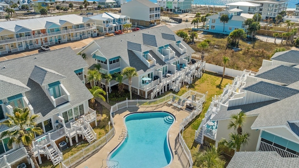A resort with multiple buildings, a central swimming pool, and a beach view. - Beachside Townhome w/ Pool |5 Decks | prime spot (Mexico Beach)