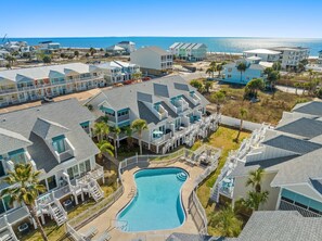 A resort with multiple buildings, a central swimming pool, and a beach view. - Beachside Townhome w/ Pool |5 Decks | prime spot (Mexico Beach)