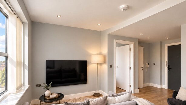 A modern living room with a flat-screen TV, a sofa, a lamp, and a view of the outside. - Luxurious ONE Bedroom Apartment IN Bond Street (Chelmsford)