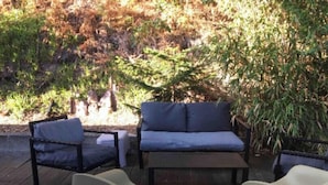 An outdoor seating area with a sofa and two chairs.