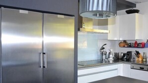A modern kitchen with stainless steel appliances, a built-in oven, and a range hood.