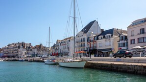 A harbor with boats docked, waterfront buildings, and a clear sky. - Apartment Pouliguen Centre (Le Pouliguen)