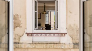 Une fenêtre donnant sur un balcon et la façade d’un immeuble.