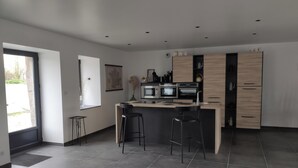 Eine moderne Küche mit einer zentralen Kochinsel, Barhocker und integrierten Geräten.