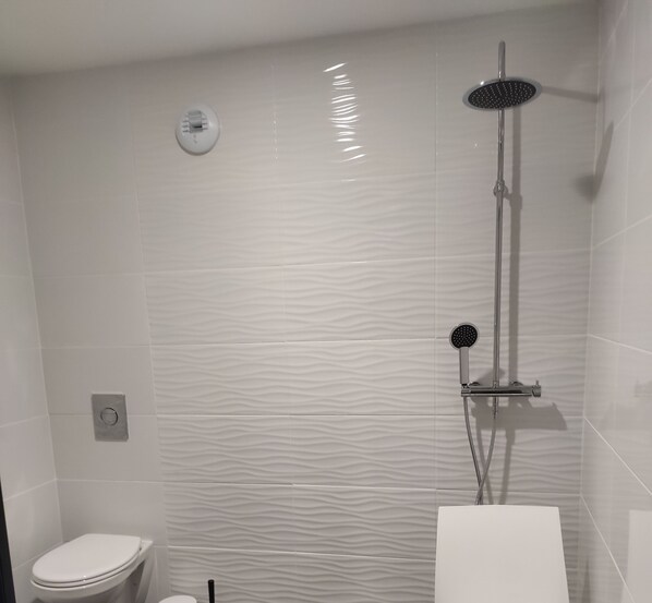A bathroom with a shower, toilet, and a wall-mounted light fixture. - VACATION HOME FOR 10 PEOPLE WITH A SPA, 15 MINUTES FROM MT. ST. MICHEL AND 30 MINUTES FROM ST. MALO (Pleine-Fougères)
