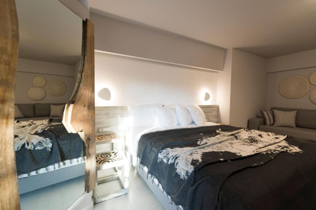 Une chambre à coucher moderne avec un grand lit, une table de chevet et un miroir.