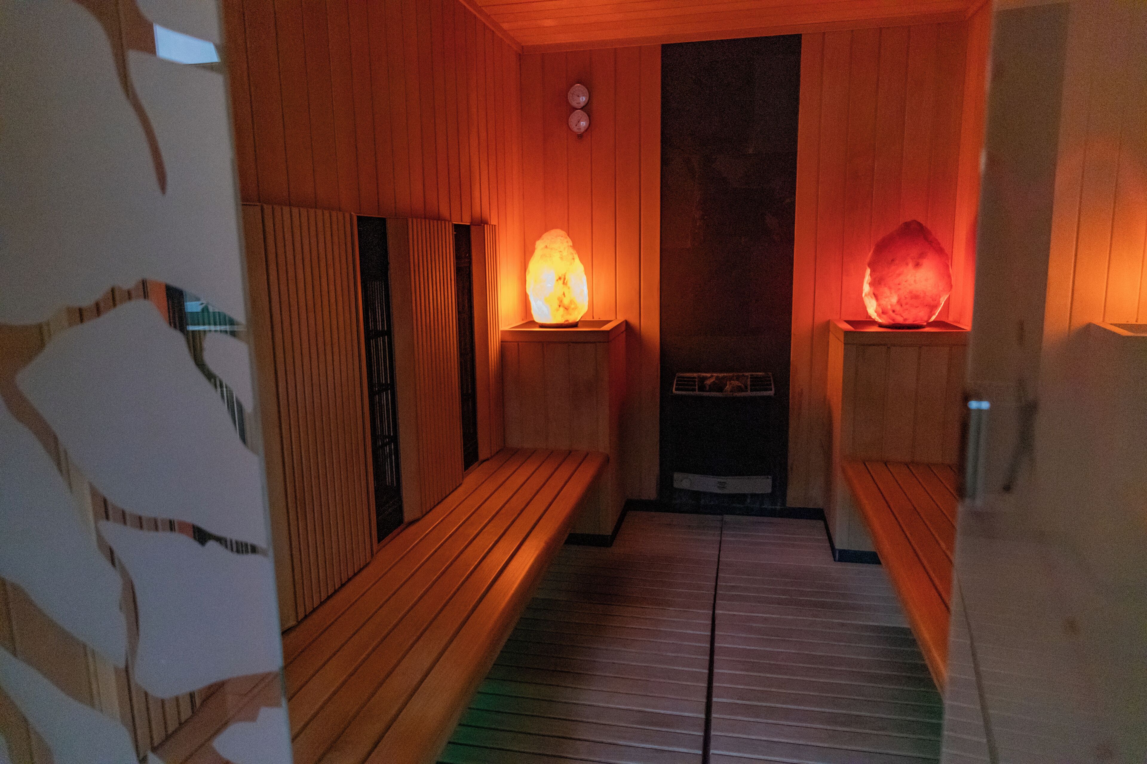 A sauna room with wooden benches and two heated stones.
