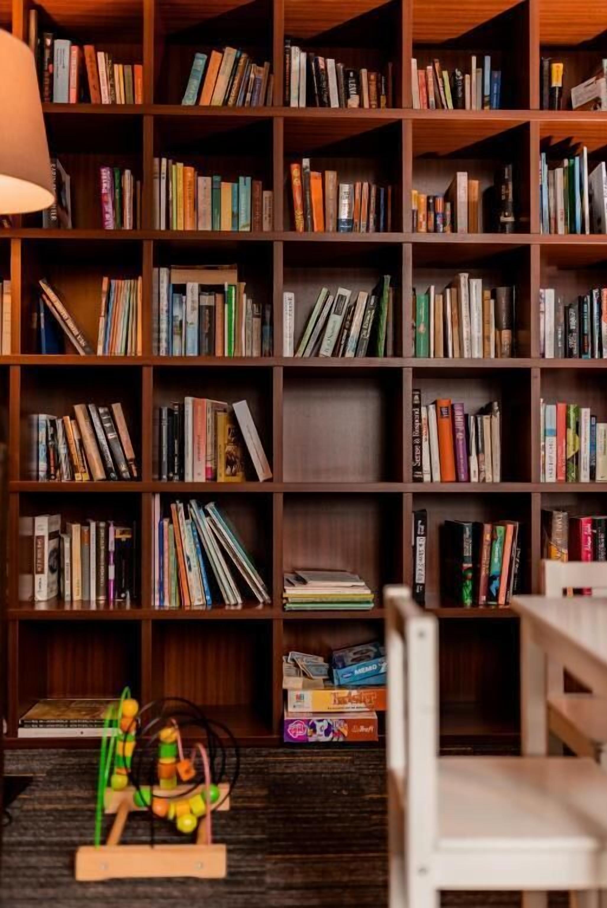 A bookshelf filled with books and a small wooden toy.