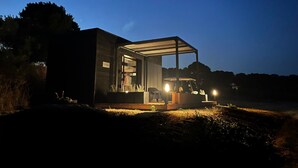 A modern, open-plan house with a covered outdoor area, a visible garage, and a well-lit interior. - Eco-lodges Lodges in Move - Domaine de Brau (Villemoustaussou)