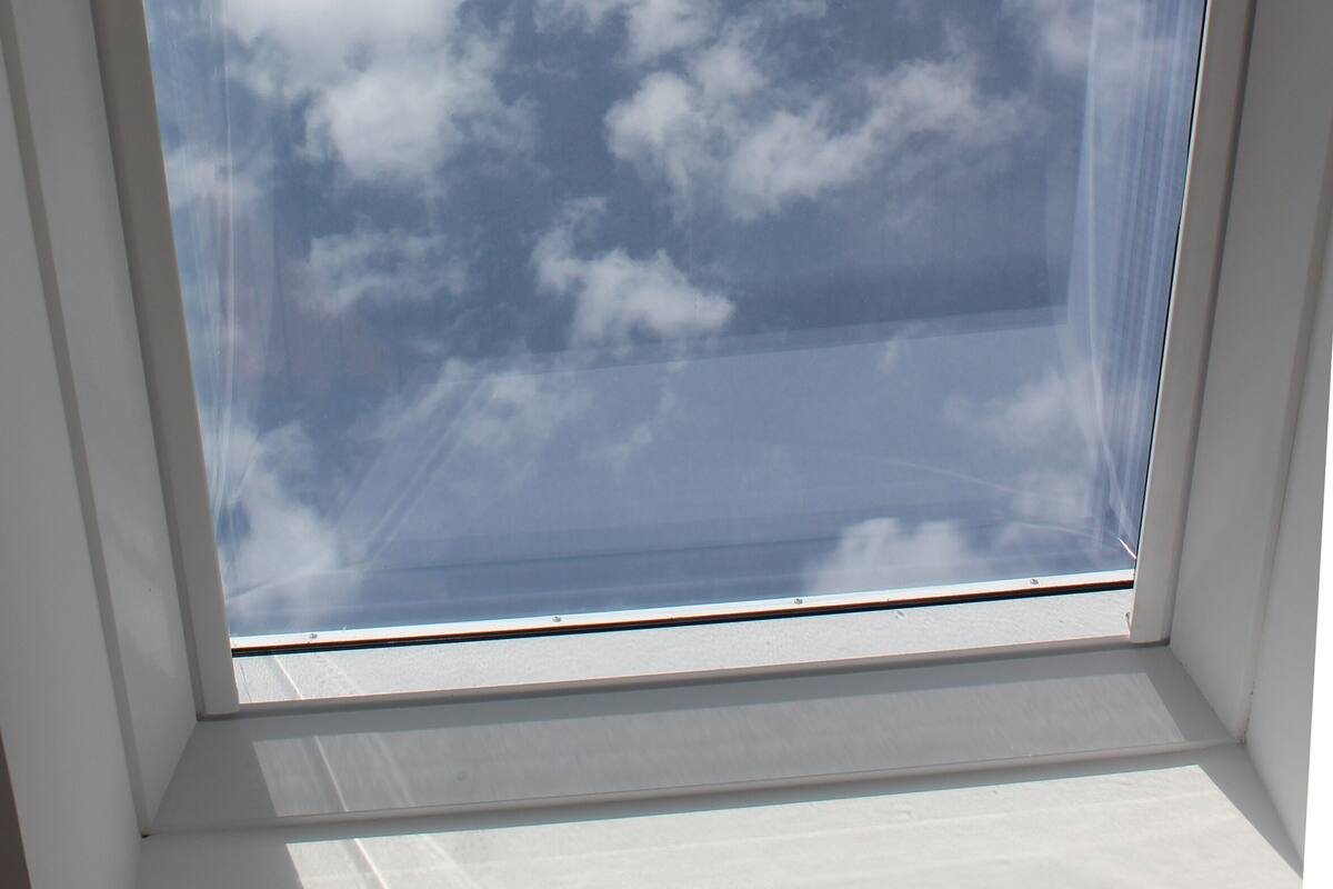 Ventana con tragaluz que ofrece una vista despejada del cielo y las nubes.
